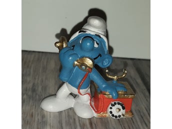 Samlar Smurf med äldre telefon.