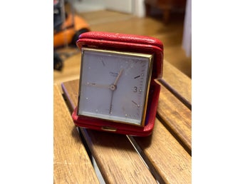 retro reseväckarklocka i rött läderfodral